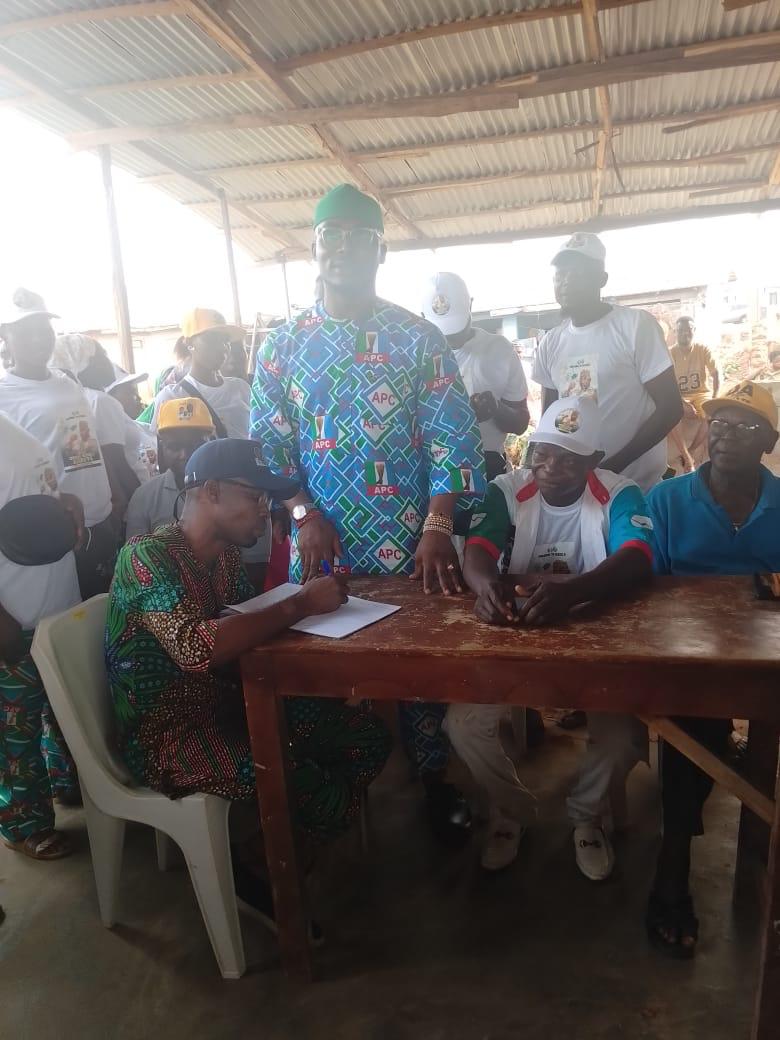 Omoba Kasali Adeboye standing with community elders at a ward meeting